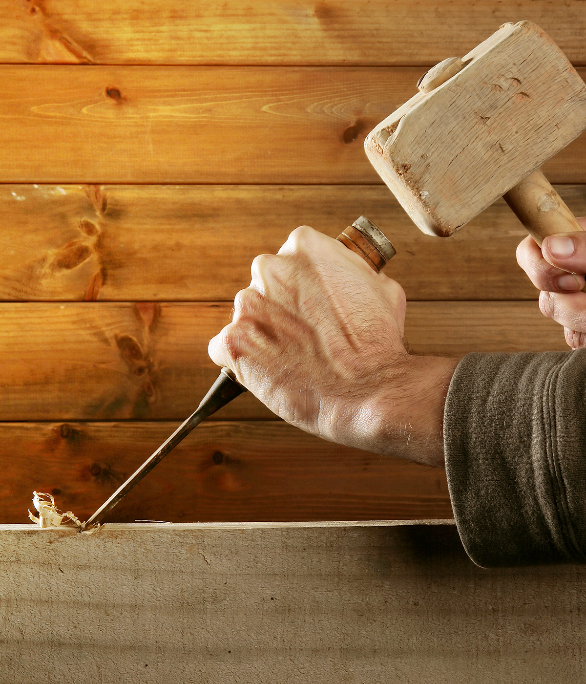 Image showing a person's hands using a mallet and chisel on wood