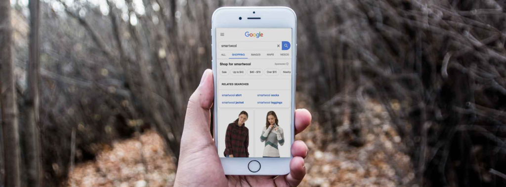 Image shows a hand carrying a phone with person shopping on google