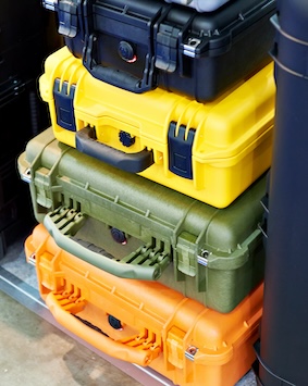 Stacked rugged toolboxes in black, yellow, green, and orange colors.