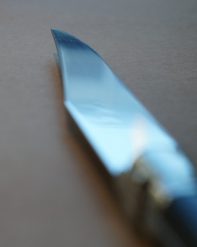 A close up image of a butter knife set on a brown background