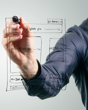 Person drawing a website layout on a transparent board